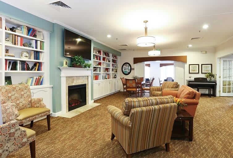 A cozy living room with a fireplace, bookshelves, and comfortable seating.