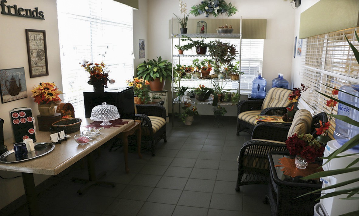 A cozy indoor seating area with abundant plants and natural light.