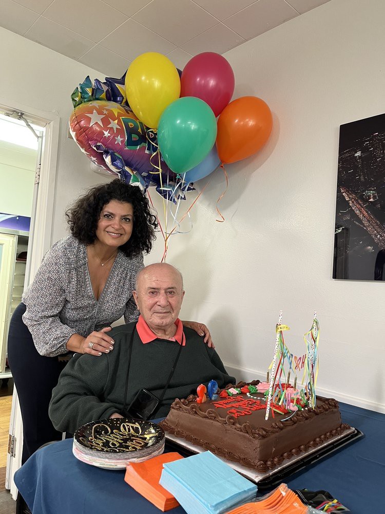 A joyful birthday celebration with balloons and a cake.