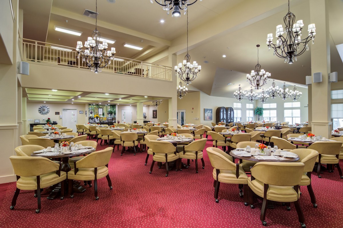 Spacious dining area with elegant chandeliers and neatly arranged tables.