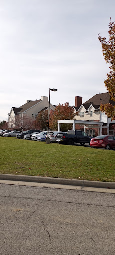 A view of a parking lot filled with cars in front of a residential or commercial building.