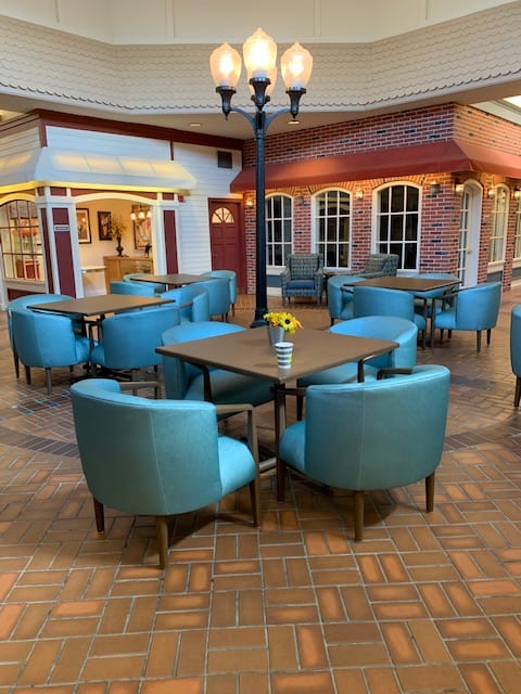 An indoor restaurant seating area with blue chairs and tables, featuring a cozy and stylish decor.