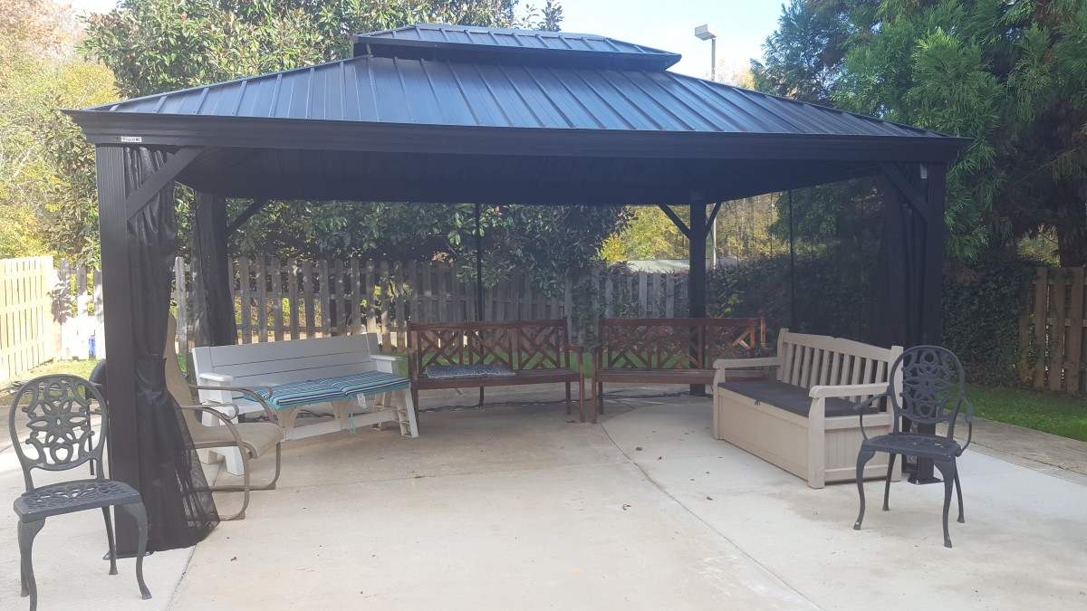 A cozy outdoor gazebo with seating areas under a shaded canopy.