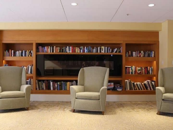 A cozy library reading area with comfortable chairs and a full bookshelf.