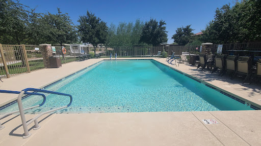 A serene outdoor swimming pool under a clear blue sky, perfect for relaxation.