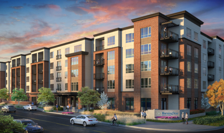 A modern apartment building with landscaping, set against a vibrant evening sky.