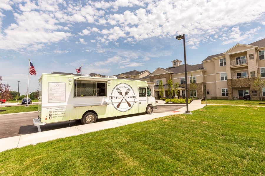 A food truck parked outside a building on a sunny day with a clear sky.