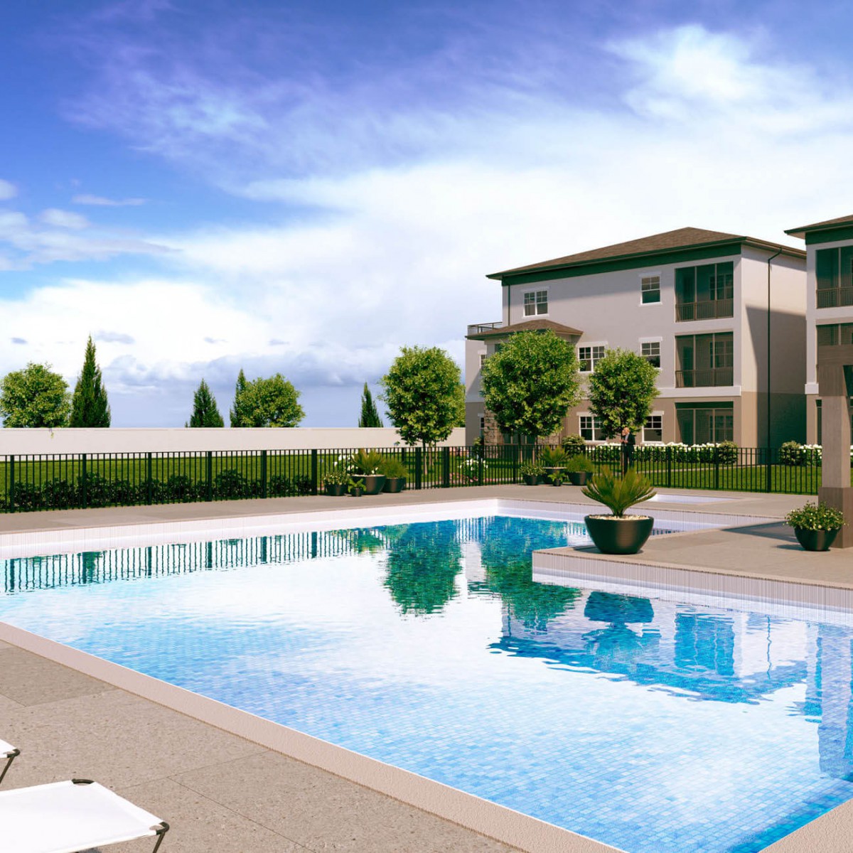 A modern residential complex featuring a large outdoor swimming pool and landscaped garden, under a clear blue sky.