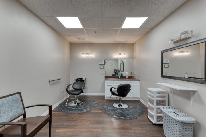 A modern hair salon interior with two styling chairs and mirrors.