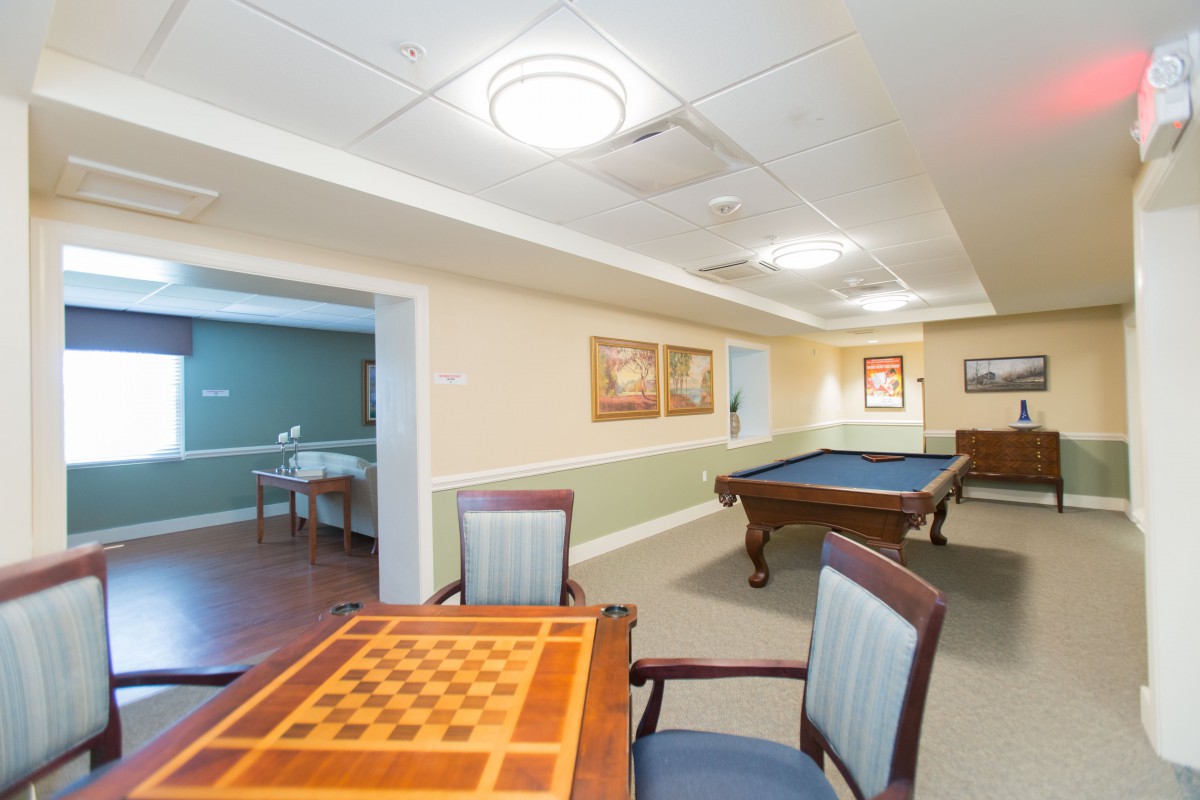 A well-lit recreation room featuring a pool table and a chess board.
