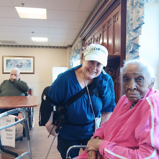 A caregiver shares a warm moment with an elderly woman in a senior living facility.