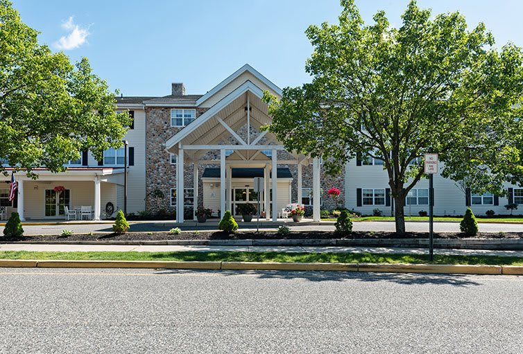 A front view of a building with a prominent entrance and surrounding trees.