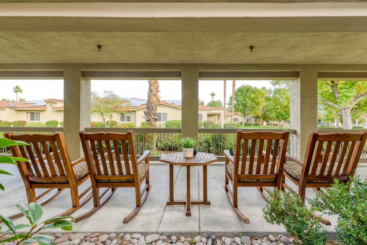 A peaceful patio with wooden rocking chairs overlooking a scenic view.