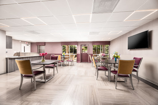 A bright and inviting dining area featuring tables, chairs, and floral arrangements.