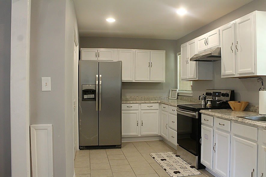 A modern kitchen featuring stainless steel appliances and white cabinetry.