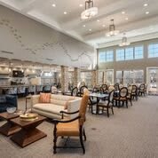 A spacious and well-lit lobby area with modern furniture and large windows.