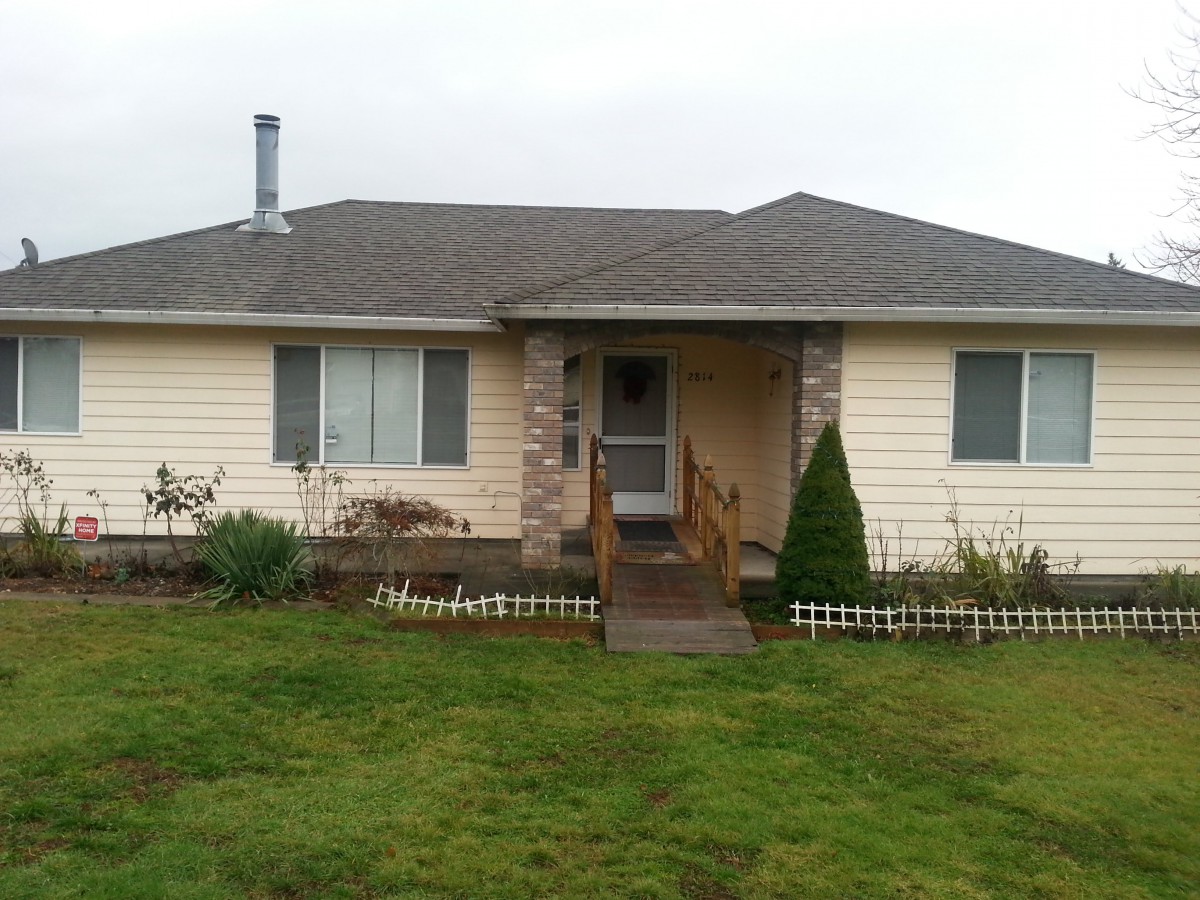 A single-story house with a chimney and a small front yard.