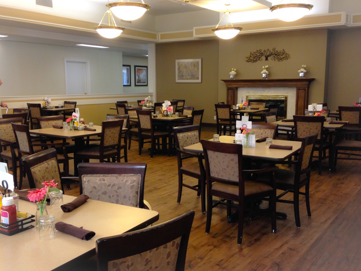 An empty dining room with neatly arranged tables and chairs, featuring a cozy atmosphere.