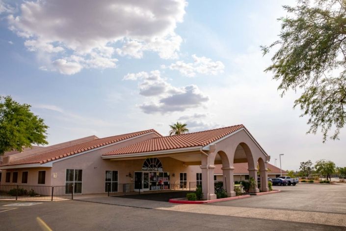A building with an arched entrance under a partly cloudy sky.