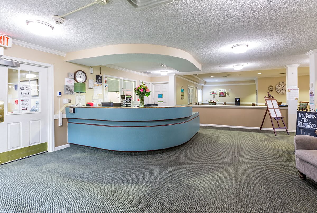 A spacious office reception area with a large, curved desk and ample lighting.