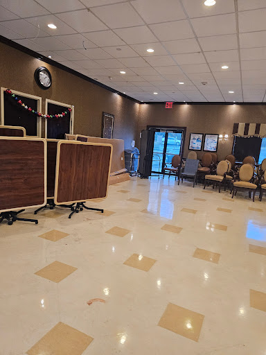 An elegantly designed lobby with wooden tables, comfortable seating, and a polished floor.