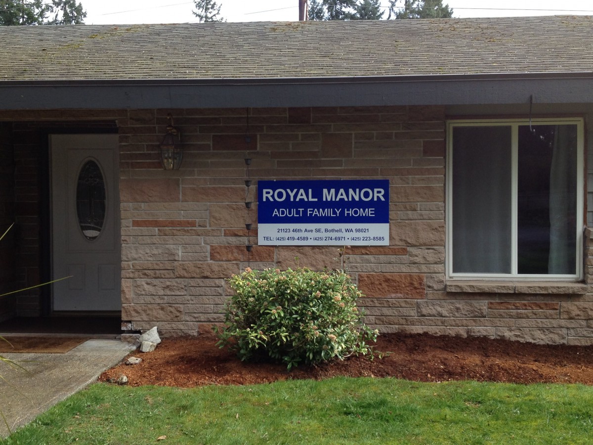 Exterior view of a residential building with a sign for Royal Manor Adult Family Home.
