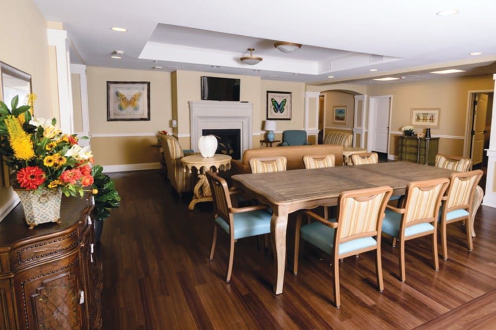 A well-decorated dining room featuring wooden tables, chairs, and a fireplace adorned with artwork.