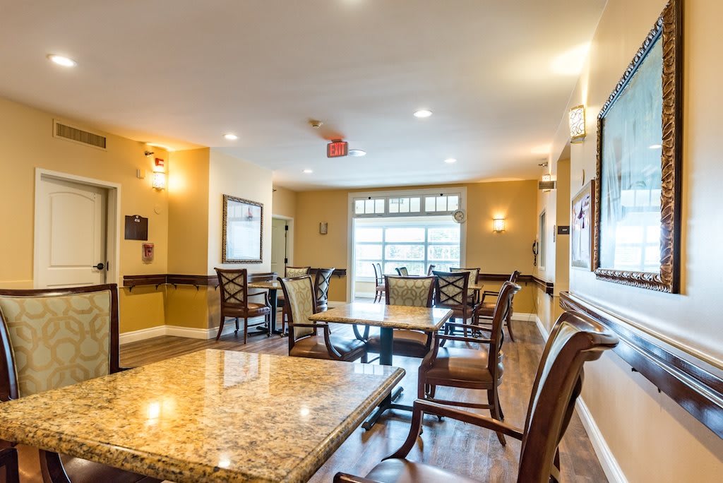 A well-lit dining area with elegant furniture and large windows.