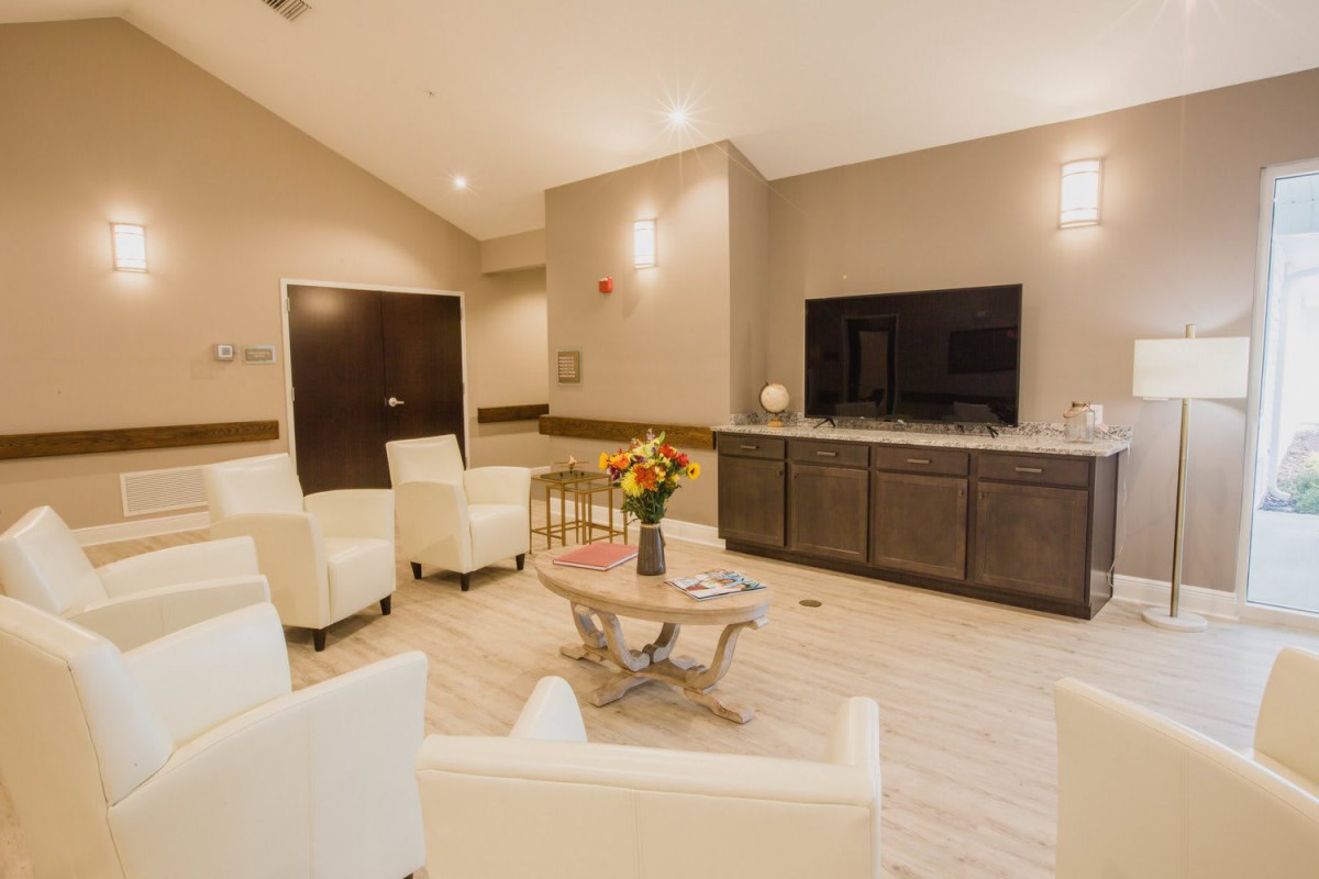 A modern waiting room featuring comfortable seating and a television.