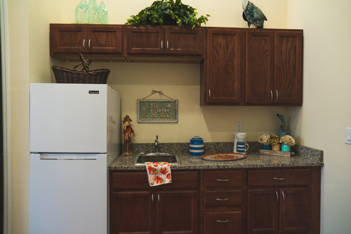 A cozy kitchen with wooden cabinets, a white refrigerator, and decorative elements.