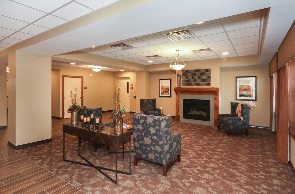 A cozy lobby with a seating area and fireplace, featuring modern decor and comfortable furniture.