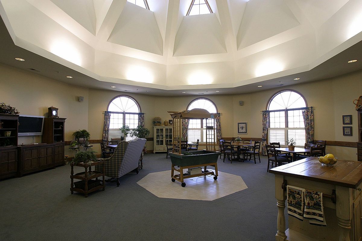 A spacious room with a dome ceiling, large windows, and various furniture pieces.