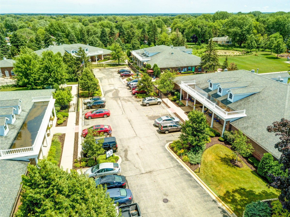 An aerial view of a parking lot surrounded by buildings and greenery.