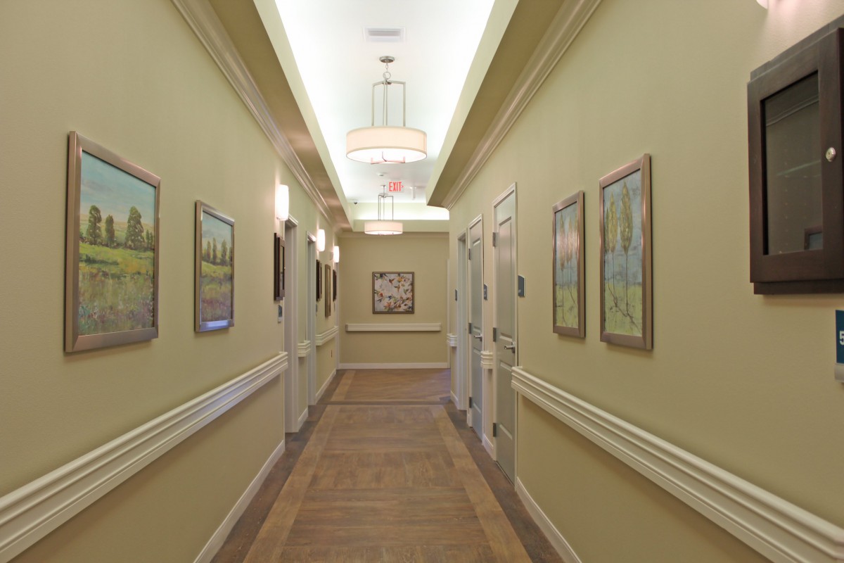 A well-lit hallway adorned with paintings on either side.