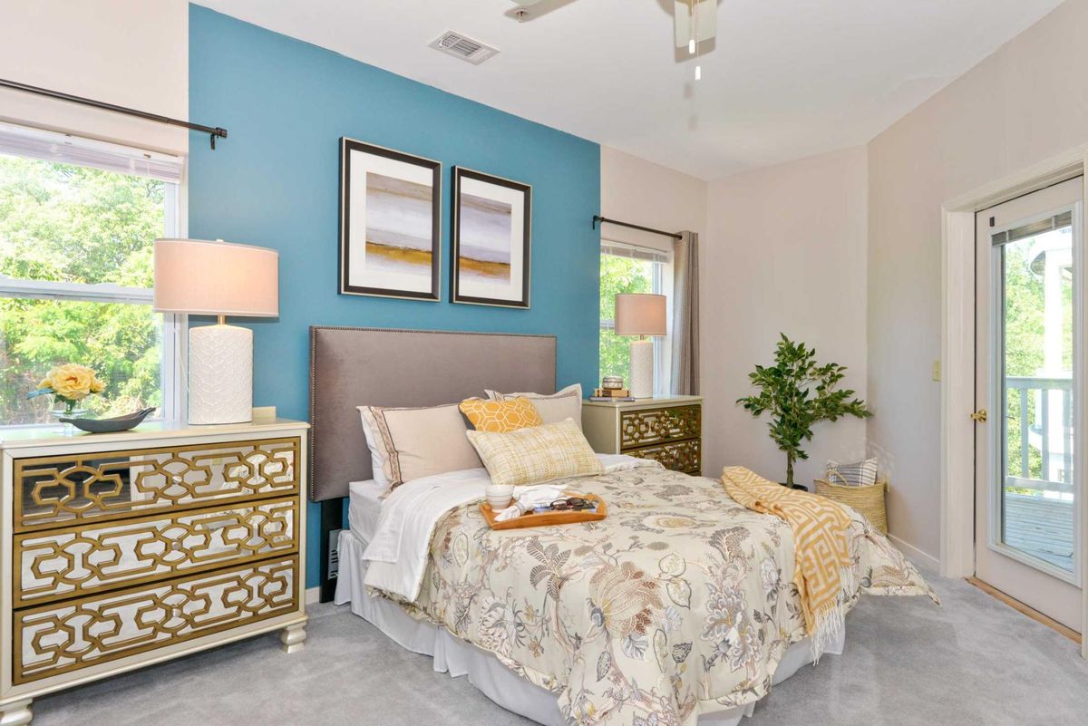 A modern bedroom with colorful walls, decorative artwork, and stylish furnishings.