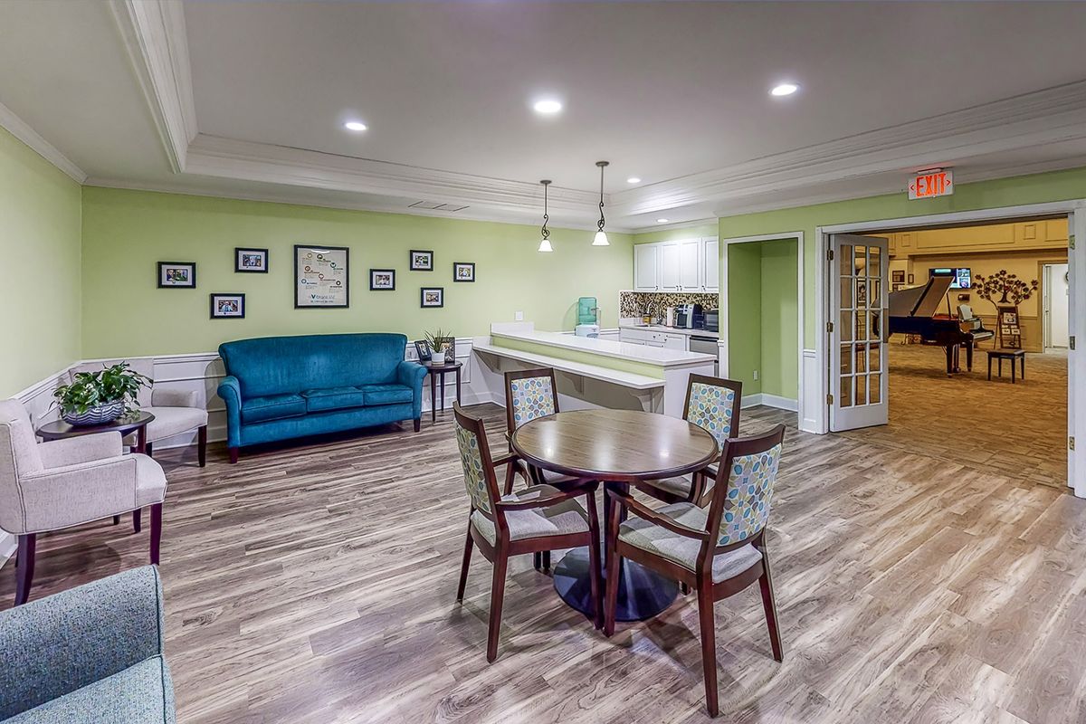 A cozy living area with a round table and chairs, adjacent to a kitchen space.