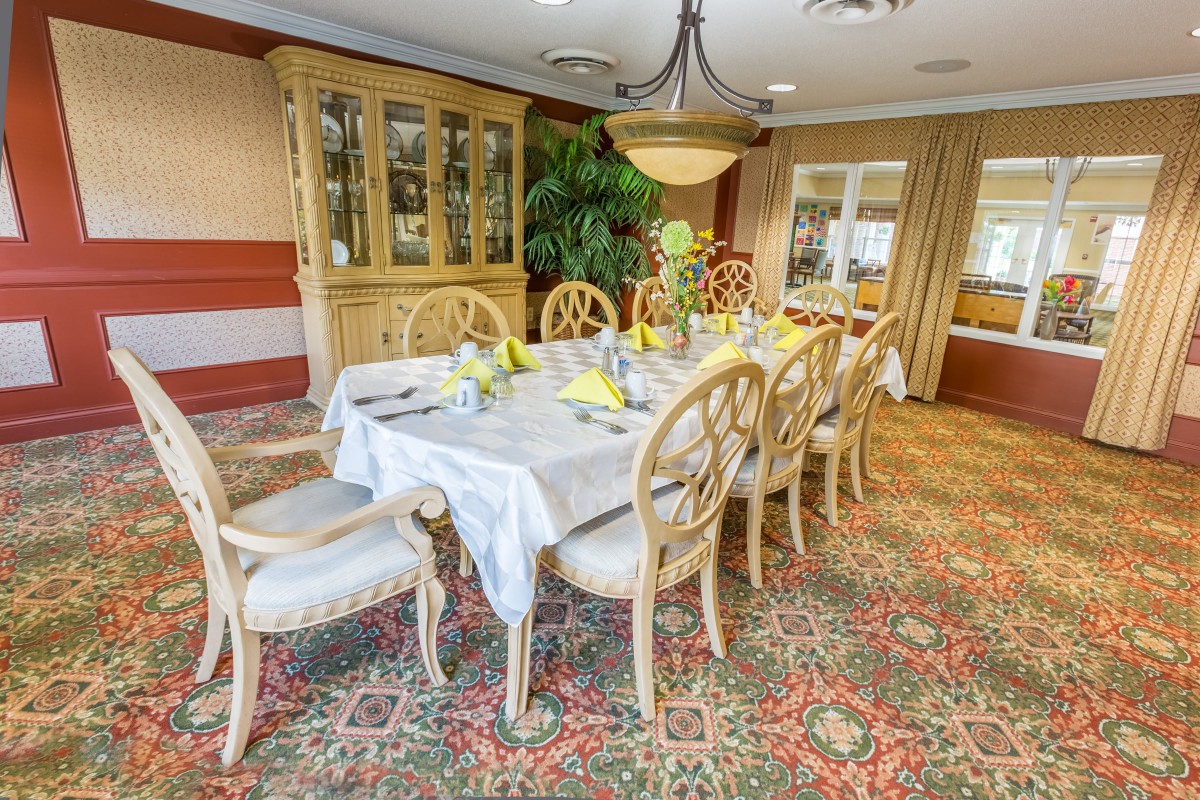 An elegantly decorated dining room with a set table and chandelier.