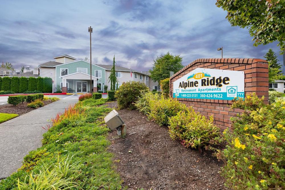 Entrance to Alpine Ridge Apartment Complex with well-maintained landscaping.