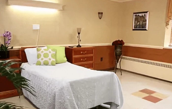 A clean and neatly arranged hospital room with a single bed.