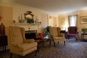 A cozy living room with traditional armchairs and a fireplace, decorated with classic accents.