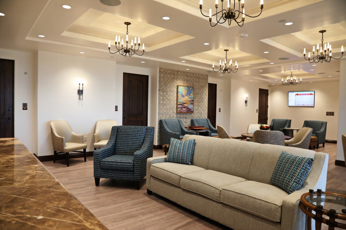 Elegant living room with plush seating and chandeliers.