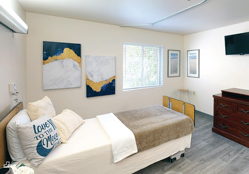 A neatly organized bedroom featuring modern artwork and a cozy atmosphere.