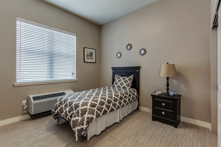 A cozy bedroom with a single bed and neutral decor.