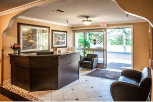 A cozy lobby area with a reception desk, seating, and artwork on the walls.