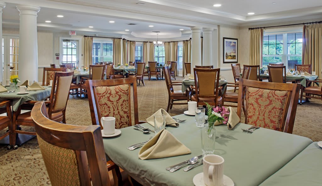 A well-appointed dining room with neatly arranged tables and chairs, featuring elegant table settings.