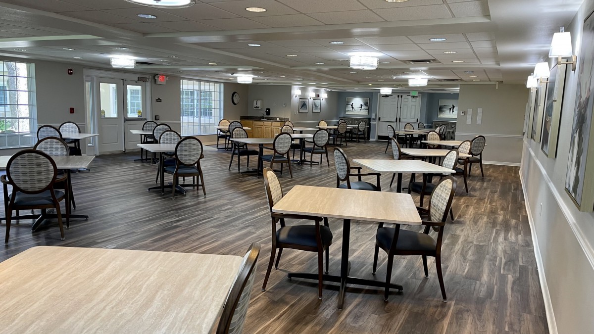 A modern, empty dining area with neatly arranged tables and chairs.