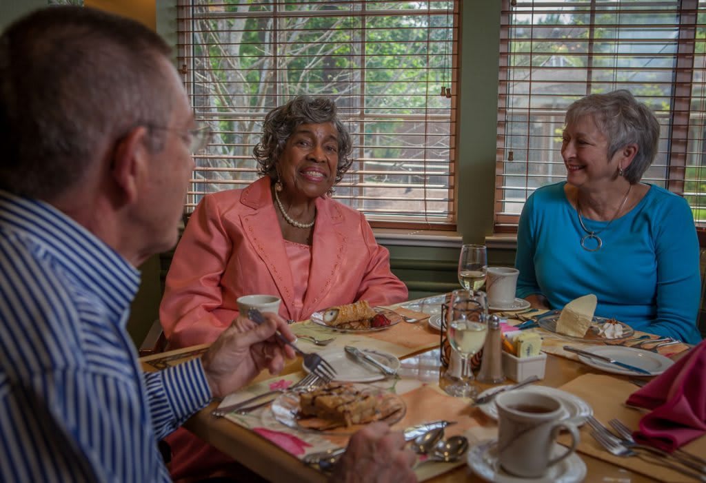 A group of seniors enjoying a meal together in a cozy restaurant setting.