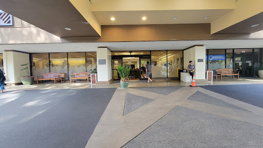 View of the entrance to a building, featuring a lobby area and pedestrians.