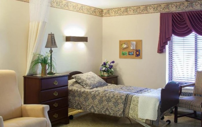 A cozy bedroom with a single bed, bedside table, and decorative elements.
