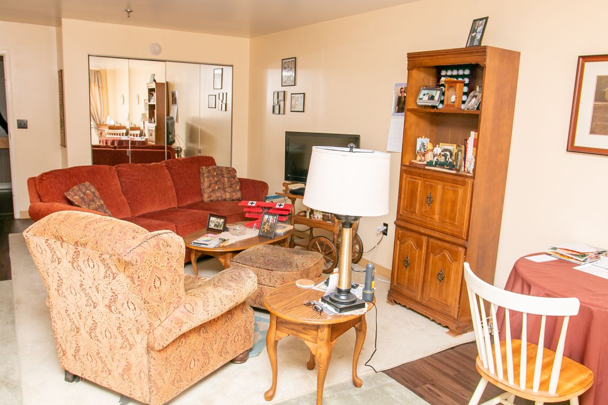 A cozy living room with comfortable seating, a television, and a wooden bookshelf.